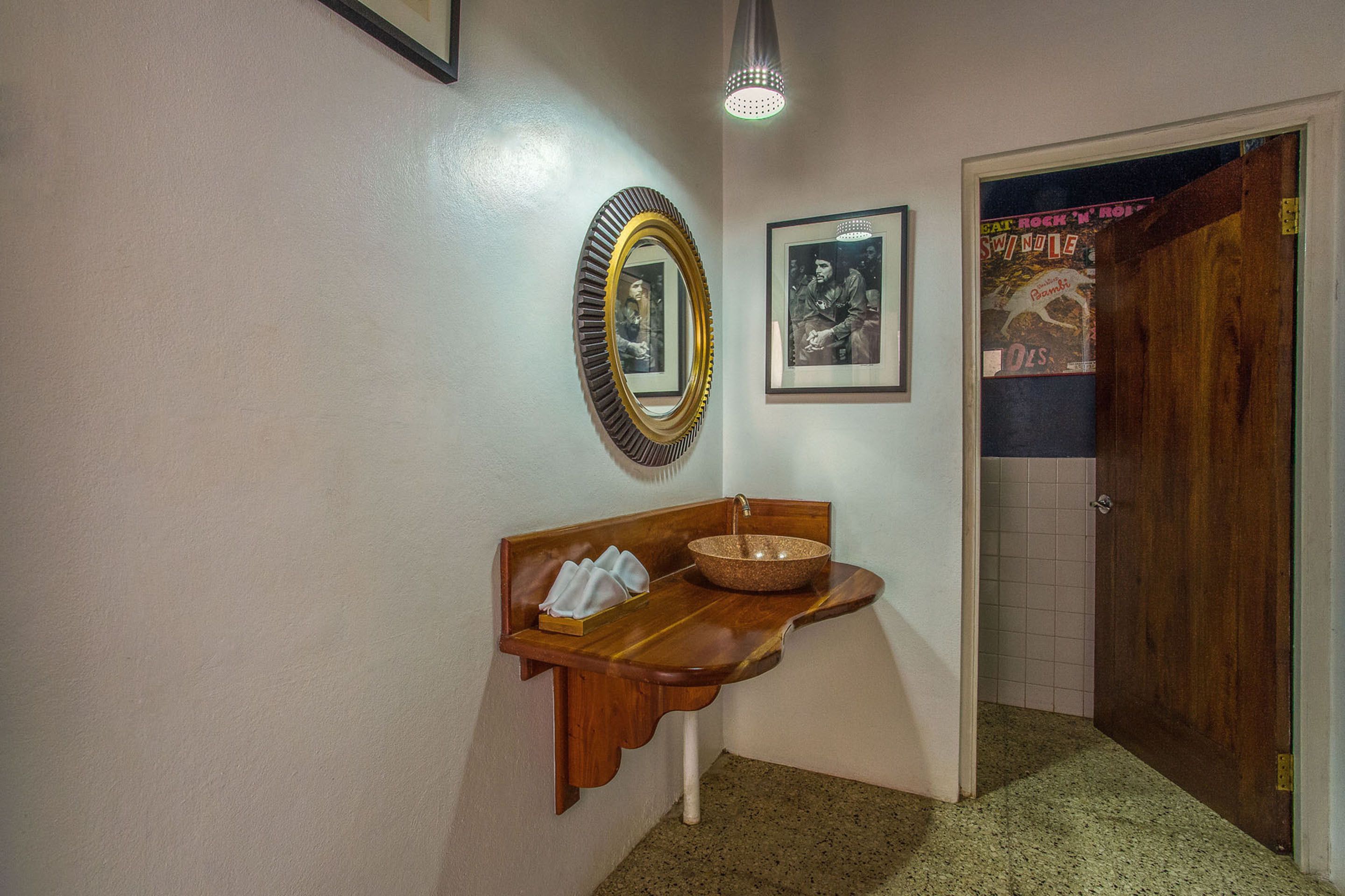 Un couloir avec un banc en bois, un miroir et un lavabo.