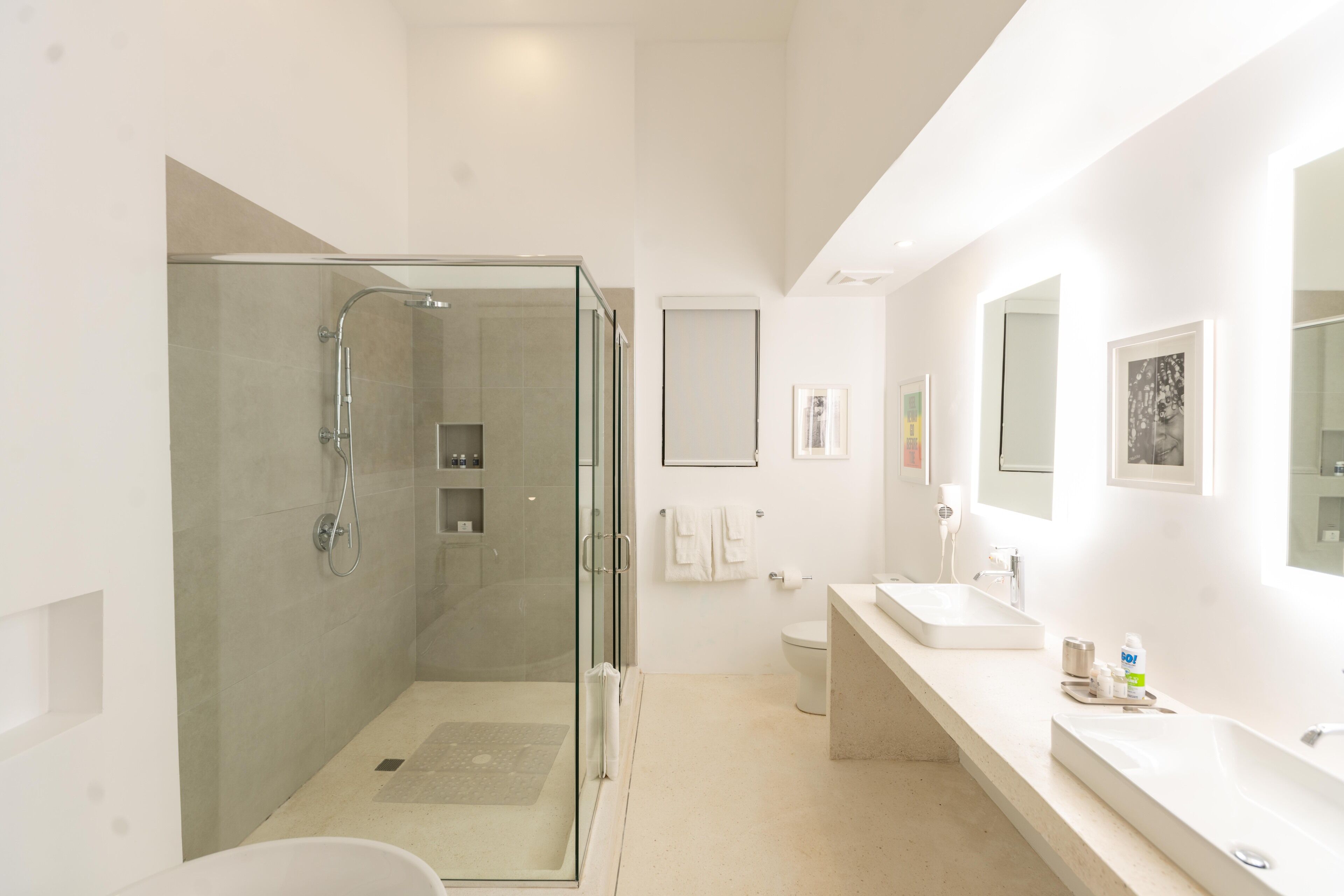 A modern bathroom with a glass-enclosed shower, a toilet, and a sink with a countertop.