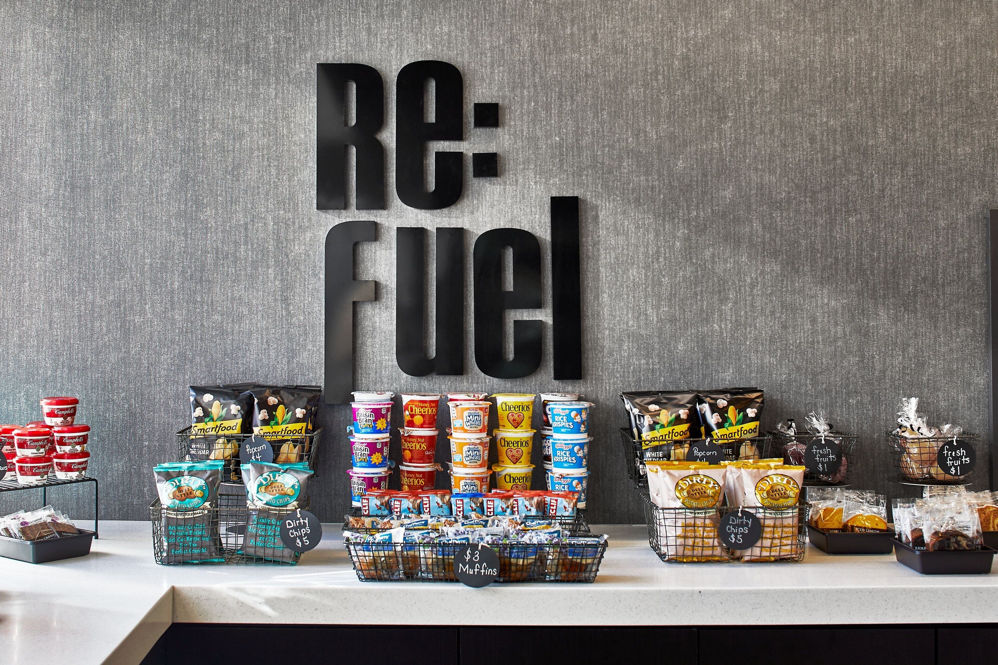 A display of snacks and beverages with a sign reading "RE: FUEL" in the background.