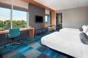 A hotel room with a large bed, a desk with a chair, a TV mounted on the wall, and a view of the outdoors. - Aloft by Marriott Nashville Franklin (Franklin)