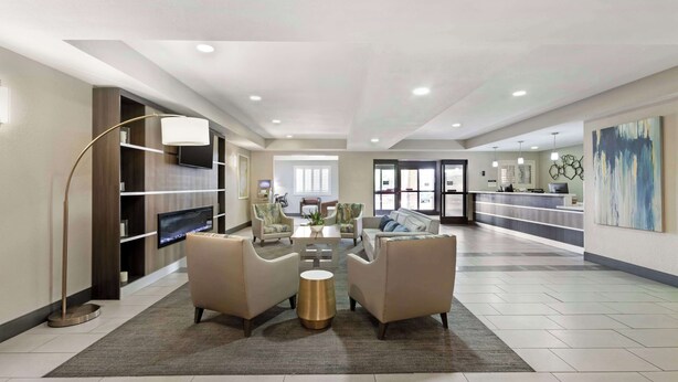 A spacious lobby with a seating area, a reception desk, and a television.