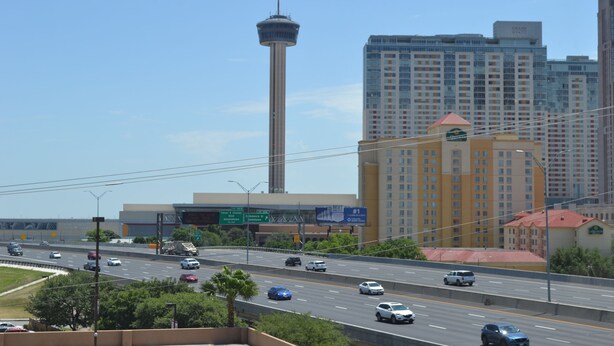 A multi-level parking garage with a central elevator shaft, surrounded by modern buildings. - Comfort Suites Alamo - Riverwalk (San Antonio)