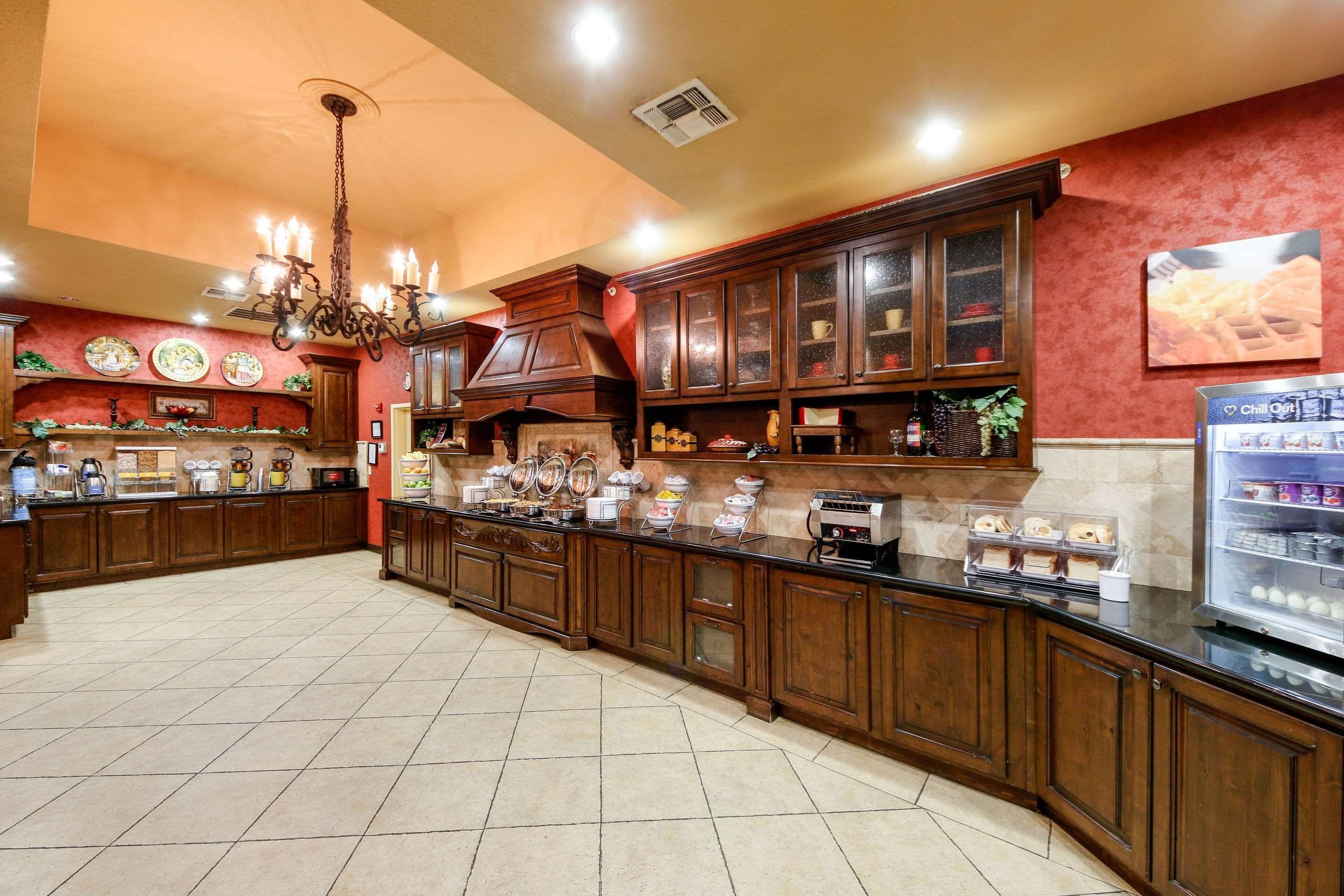 A spacious kitchen with wooden cabinets, a central island, and various appliances.
