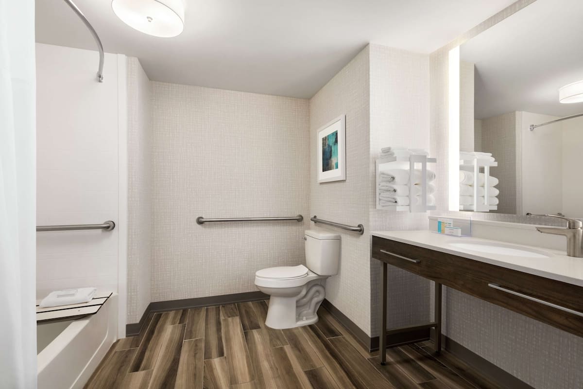 A modern bathroom with a shower, toilet, and vanity.