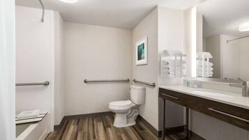 Un baño moderno con ducha, inodoro y tocador.