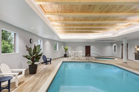 Una piscina techada, sillones reclinables de piscina