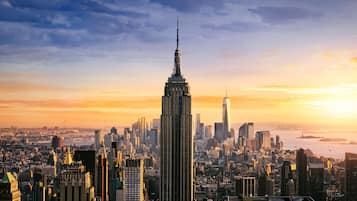 Un paisaje urbano con un rascacielos destacado, probablemente el Empire State Building, rodeado de otros edificios altos.