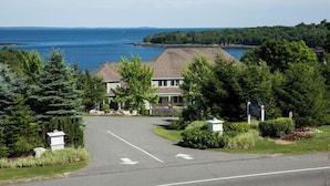 A residential area with a house, a driveway, and a view of the sea.