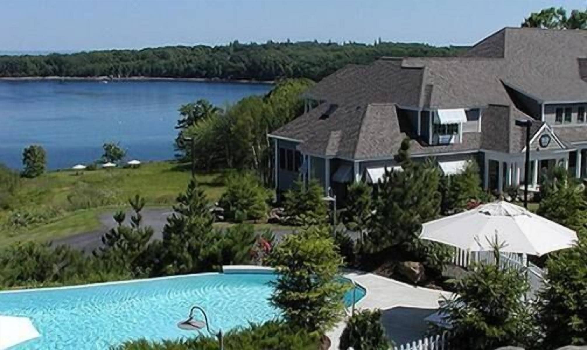 Una casa grande con piscina y vista a un lago.