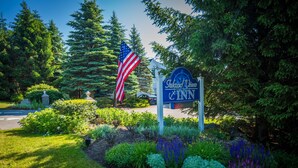 A sign for Island View Inn surrounded by lush greenery and a flag.