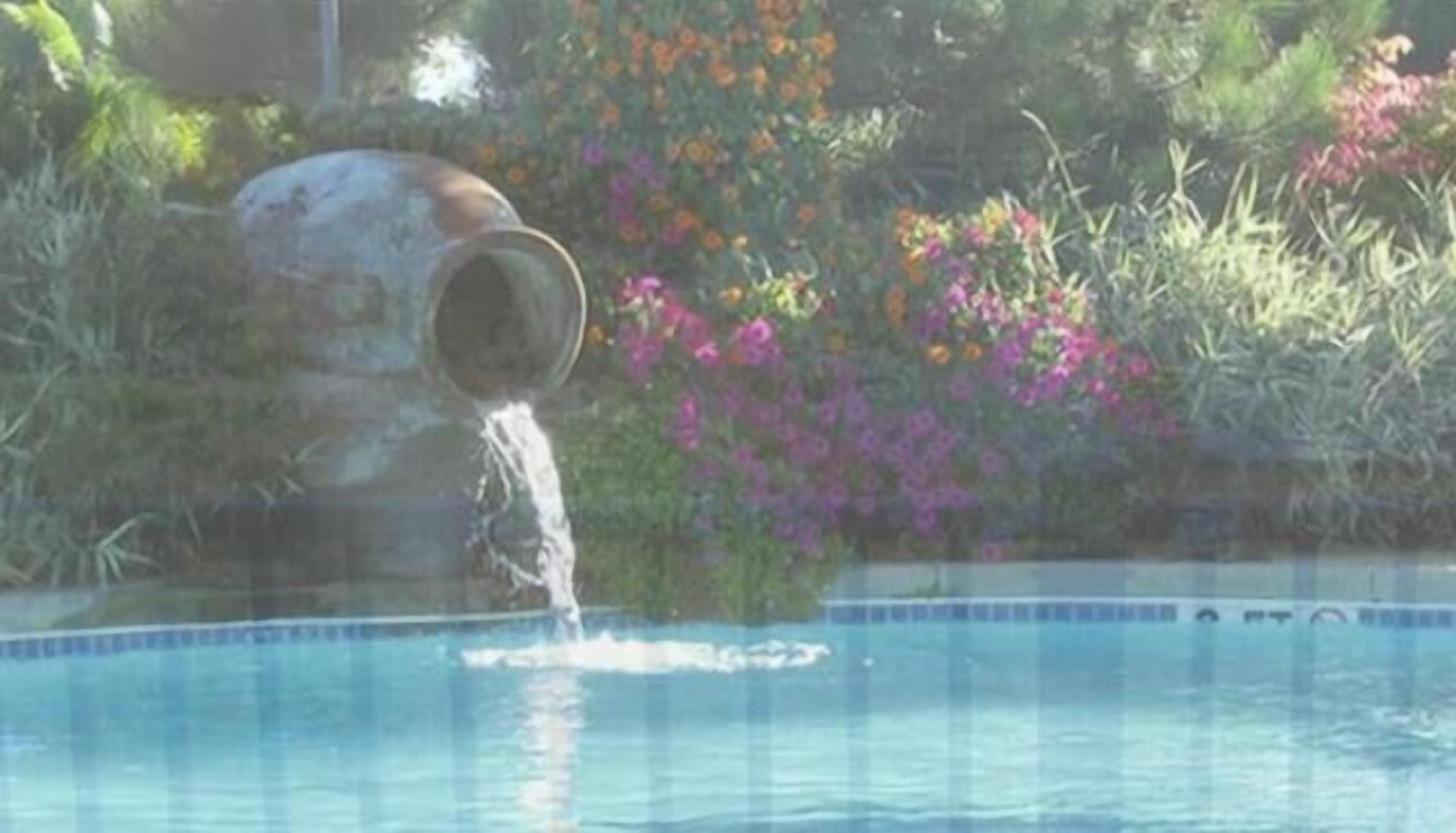 Una piscina con una estructura de concreto sumergida parcialmente en el agua.