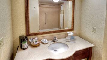 Une salle de bain équipée d’un lavabo, d’un miroir et d’articles de toilette.