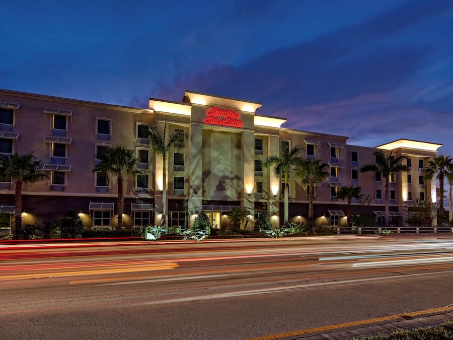 A hotel with a prominent sign, multiple floors, and a well-lit facade.