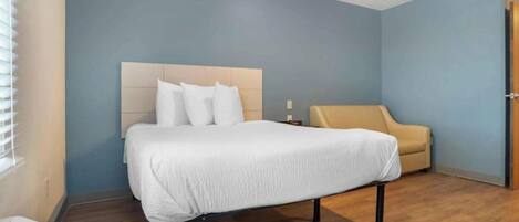 Ein Hotelzimmer mit einem Bett, einer Couch und Holzboden.