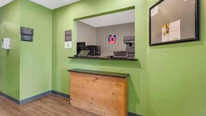 Un área de recepción con una pared verde, una barra de madera y un letrero con el número 6.