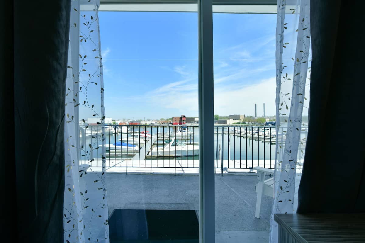 Ein Balkon mit Blick auf einen Yachthafen und Gebäude in der Ferne.
