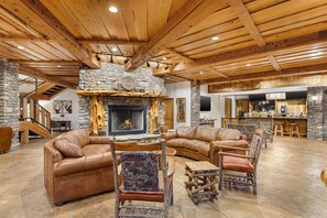 A spacious living area with a stone fireplace, leather sofas, and rustic wooden furniture. - Hilton Grand Vacations Club Stonewater Cove Shell Knob (Shell Knob)