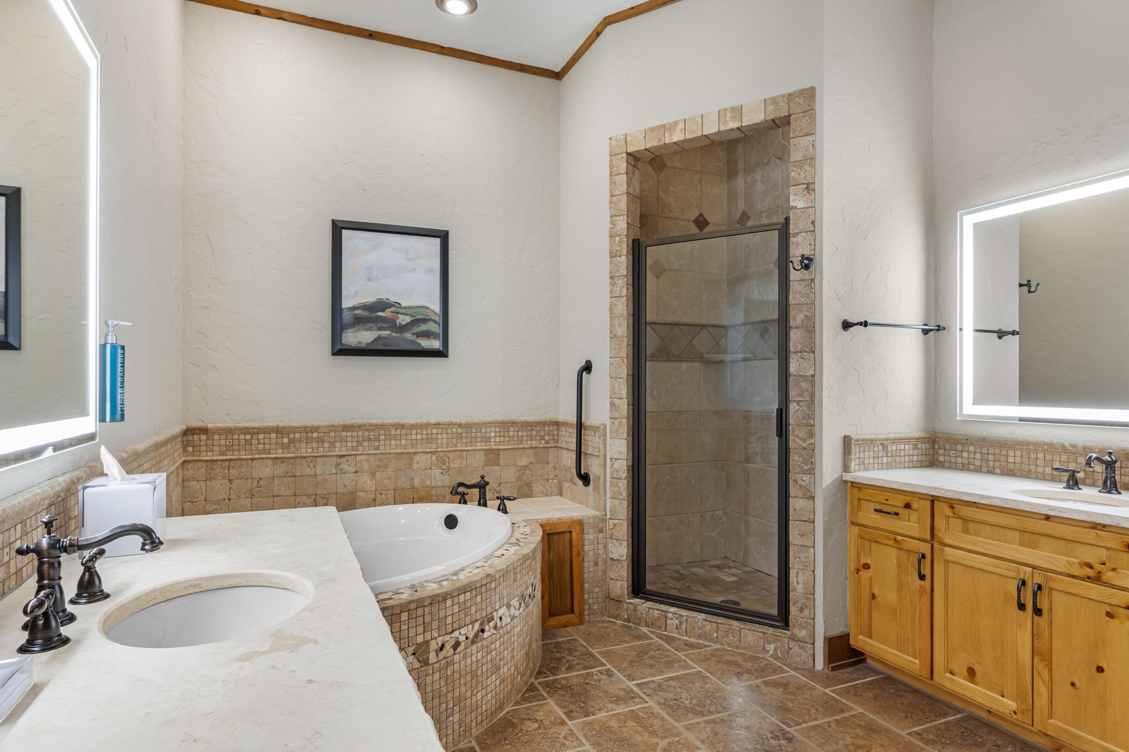 A bathroom with a bathtub, a shower, and a sink.