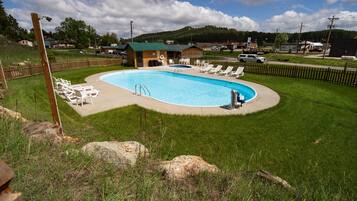 Relax by the pool surrounded by lush greenery and scenic hills.