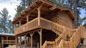 A wooden cabin with a balcony and a staircase leading to the entrance. - Rock Crest Lodge And Cabins (Custer)