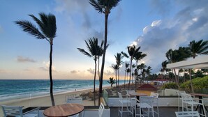A beachside patio with white metal chairs and tables, overlooking the ocean. - Grand Bavaro Princess - All Inclusive (Punta Cana)