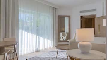 Una habitación de hotel moderna con una mesa redonda, un sofá y una lámpara.