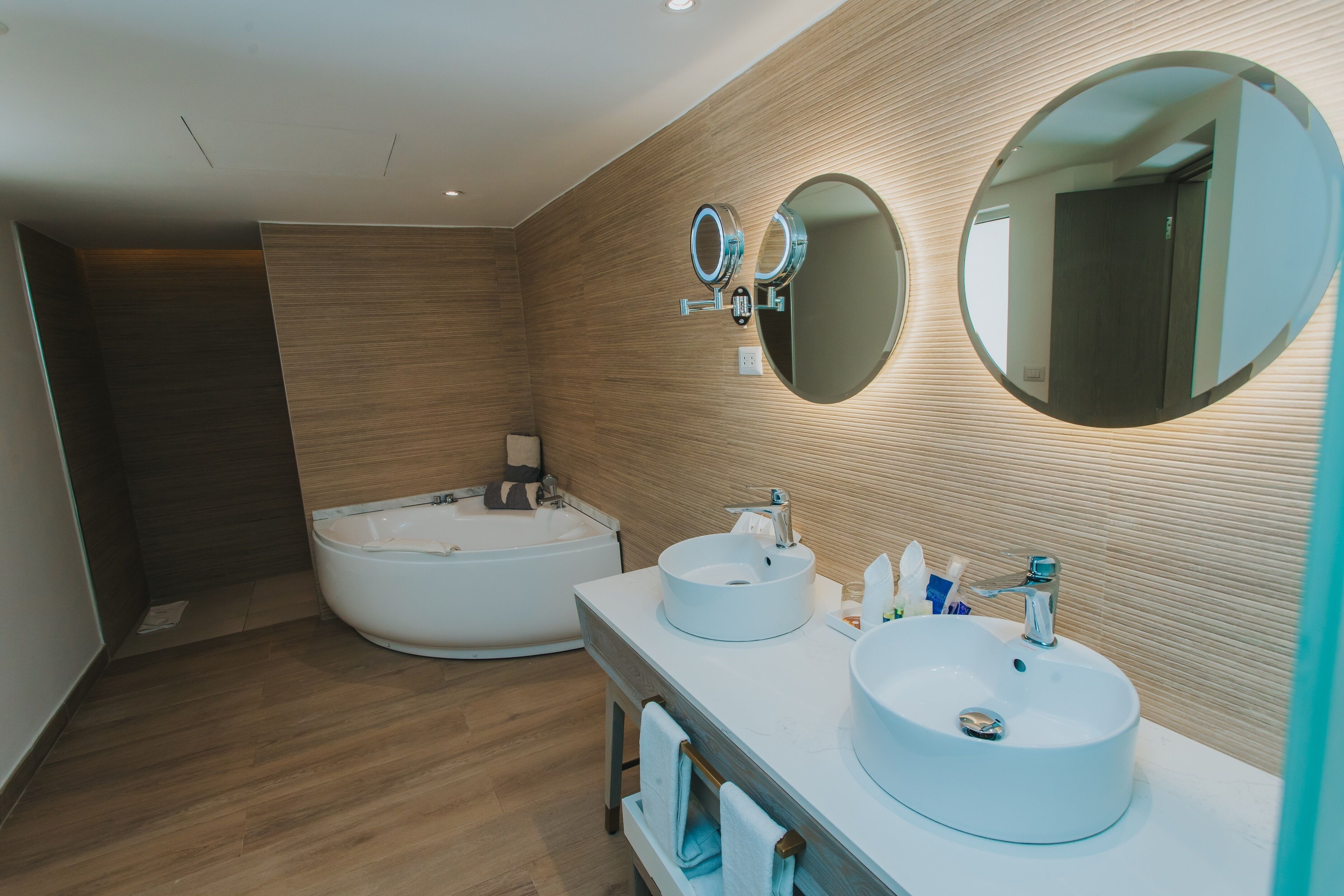 Une salle de bain moderne avec une grande baignoire, deux lavabos et un miroir.