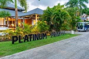 A hotel entrance with a sign reading "PLATINUM PRINCESS" and a paved pathway leading to the building.