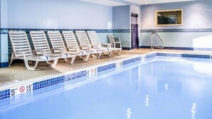 Ein Schwimmbecken mit Liegestühlen und einem Sprungbrett.