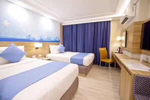 A hotel room with two beds, a desk, a chair, a TV, and a large window with curtains. - Crown Regency Hotel Makati (Makati)