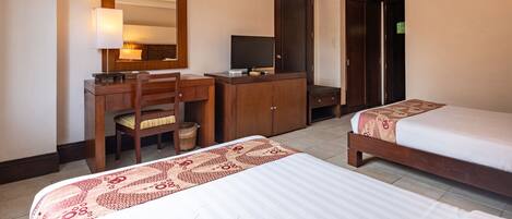 A hotel room with a bed, a desk with a chair, a television, and a wardrobe.