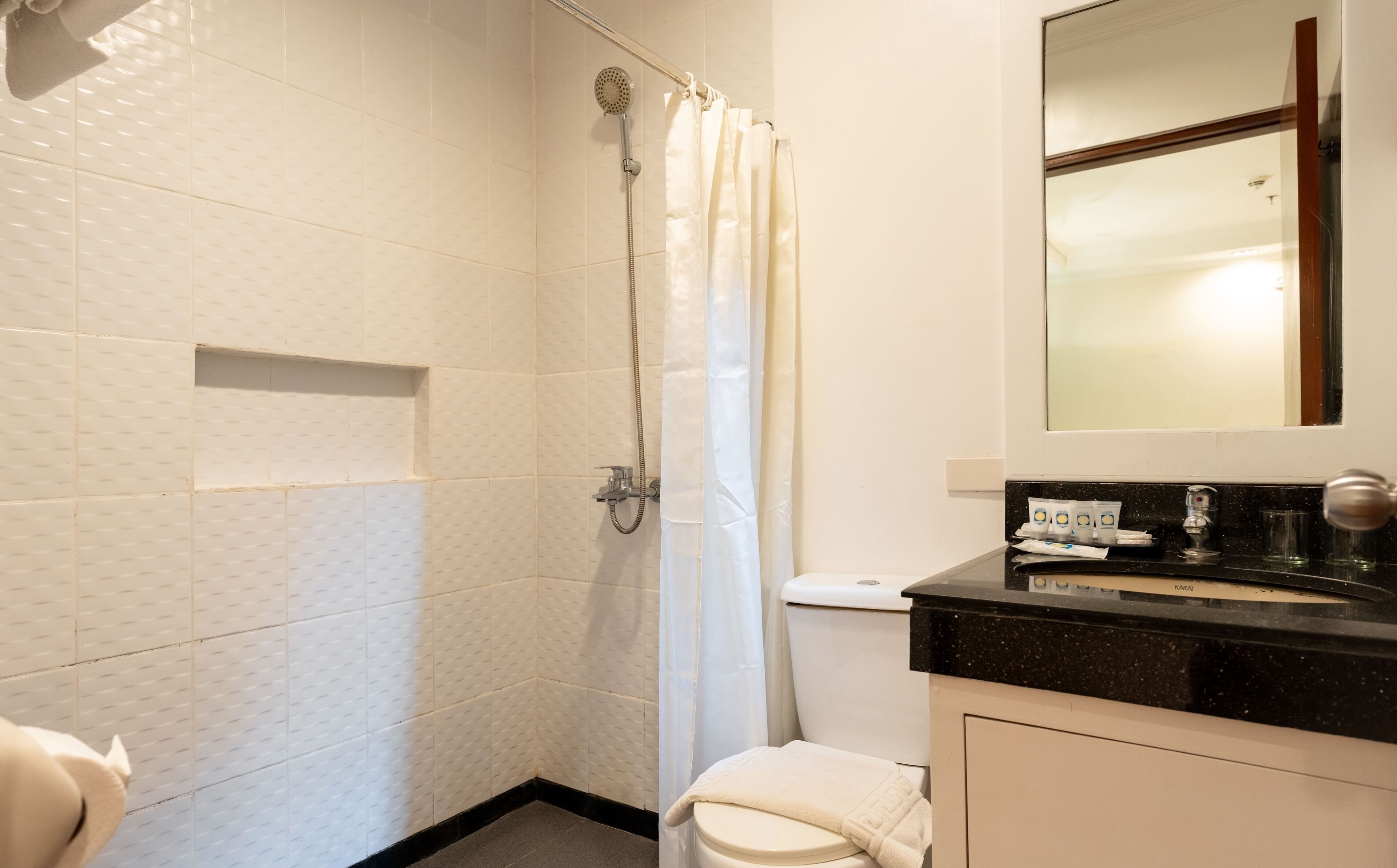 A bathroom with a shower, toilet, and sink.