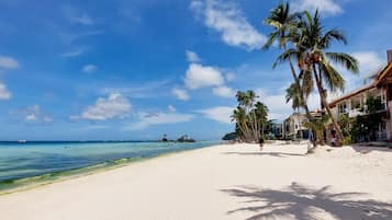 On the beach, white sand, sun loungers, beach umbrellas