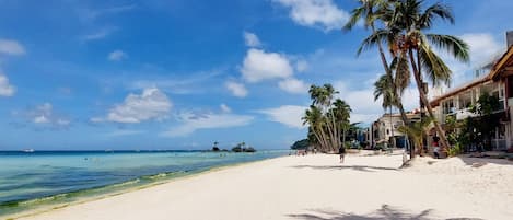 On the beach, white sand, sun loungers, beach umbrellas