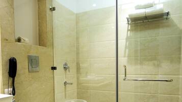 A modern bathroom with a glass-enclosed shower, a toilet, a sink, and a telephone.