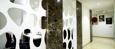 A modern interior with a marble column, white decorative panels, and a clean, minimalist design.