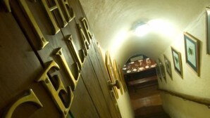 A narrow, dimly lit hallway with wooden doors labeled "The Cellar." - Granny Mouse Country House & Spa (Lidgetton West)