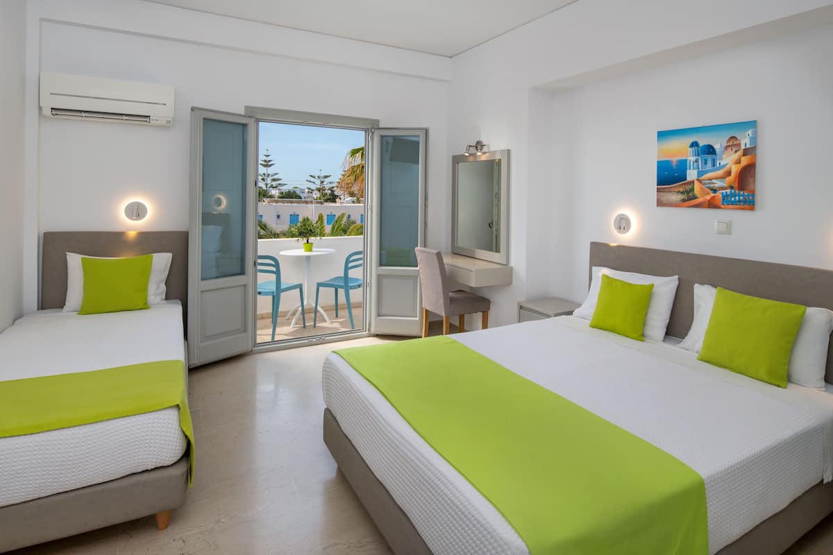 Ein Hotelzimmer mit zwei Betten, einem Schreibtisch und einem Balkon mit Blick.