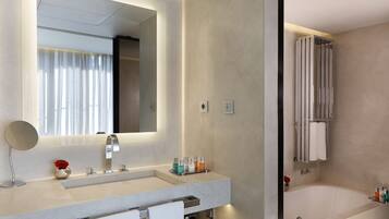 Un baño moderno con un espejo grande, lavamanos dobles, una bañera y zona de ducha.