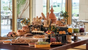Una mesa de buffet con una variedad de pasteles, frutas y bebidas.