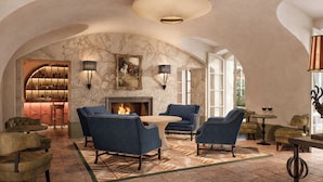 A spacious lounge area with a fireplace, comfortable seating, and a bar with bottles.