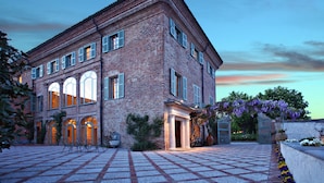 A large brick building with a courtyard, arched windows, and a covered entrance.