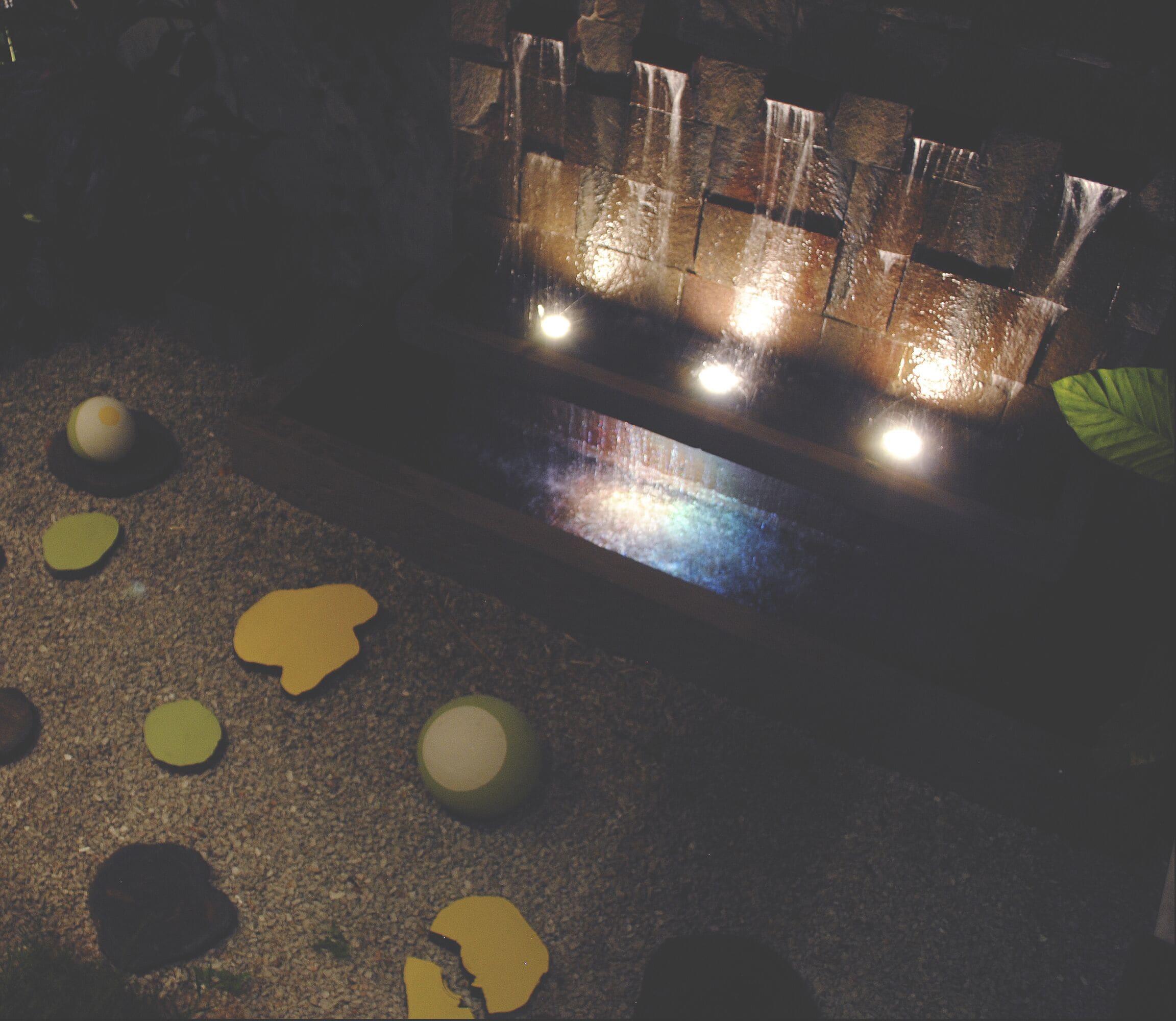 A fireplace with four lights, surrounded by scattered leaves on the floor.