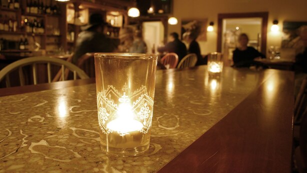 Un bar con una vela en un portavelas sobre la barra.
