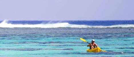 Une personne fait du kayak sur une mer calme, à bord d’un kayak jaune.