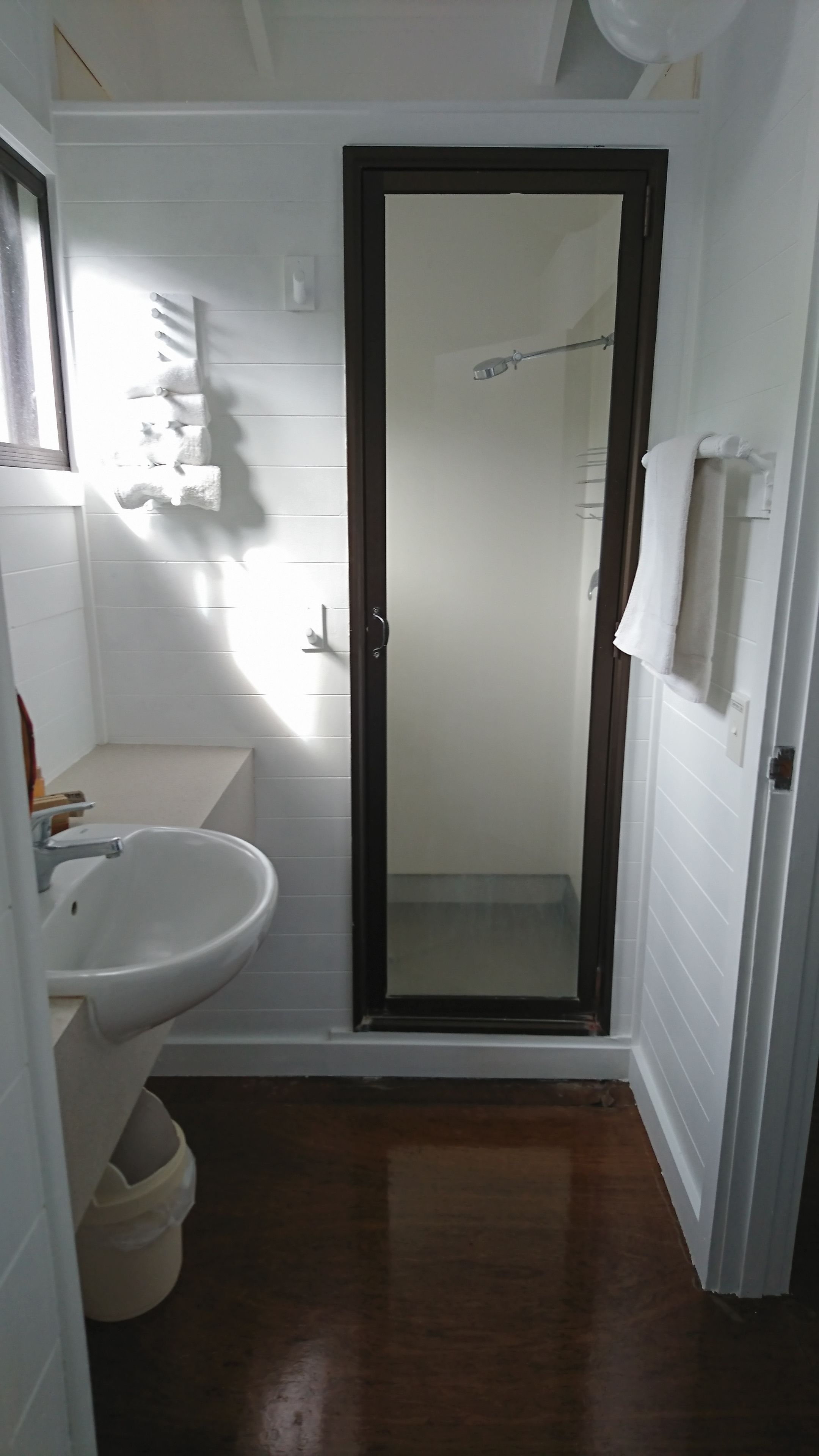 Un baño pequeño con lavamanos blanco, inodoro y zona de ducha.