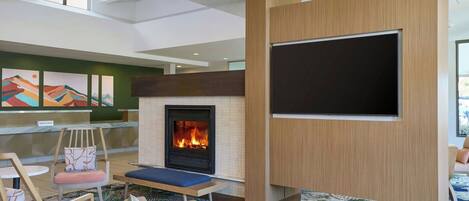 A lobby with a fireplace, seating area, and artwork on the walls.