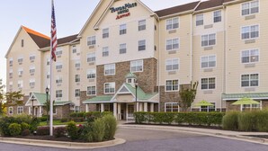 A multi-story hotel with a prominent American flag, a stone facade, and a green roof.