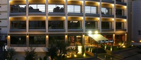 A multi-story hotel with a central staircase and a sign reading "Blue Sea Hotel".