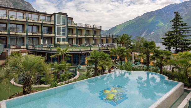 Un hôtel doté d’une piscine, de balcons et offrant une vue sur un paysage montagneux.